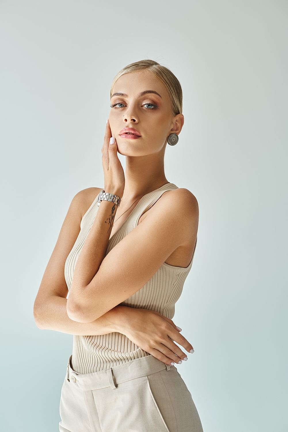 Woman in neutral outfit posing confidently.