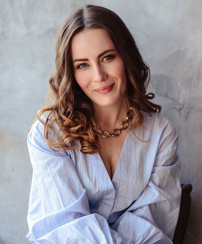 Woman smiling in a blue striped blouse.