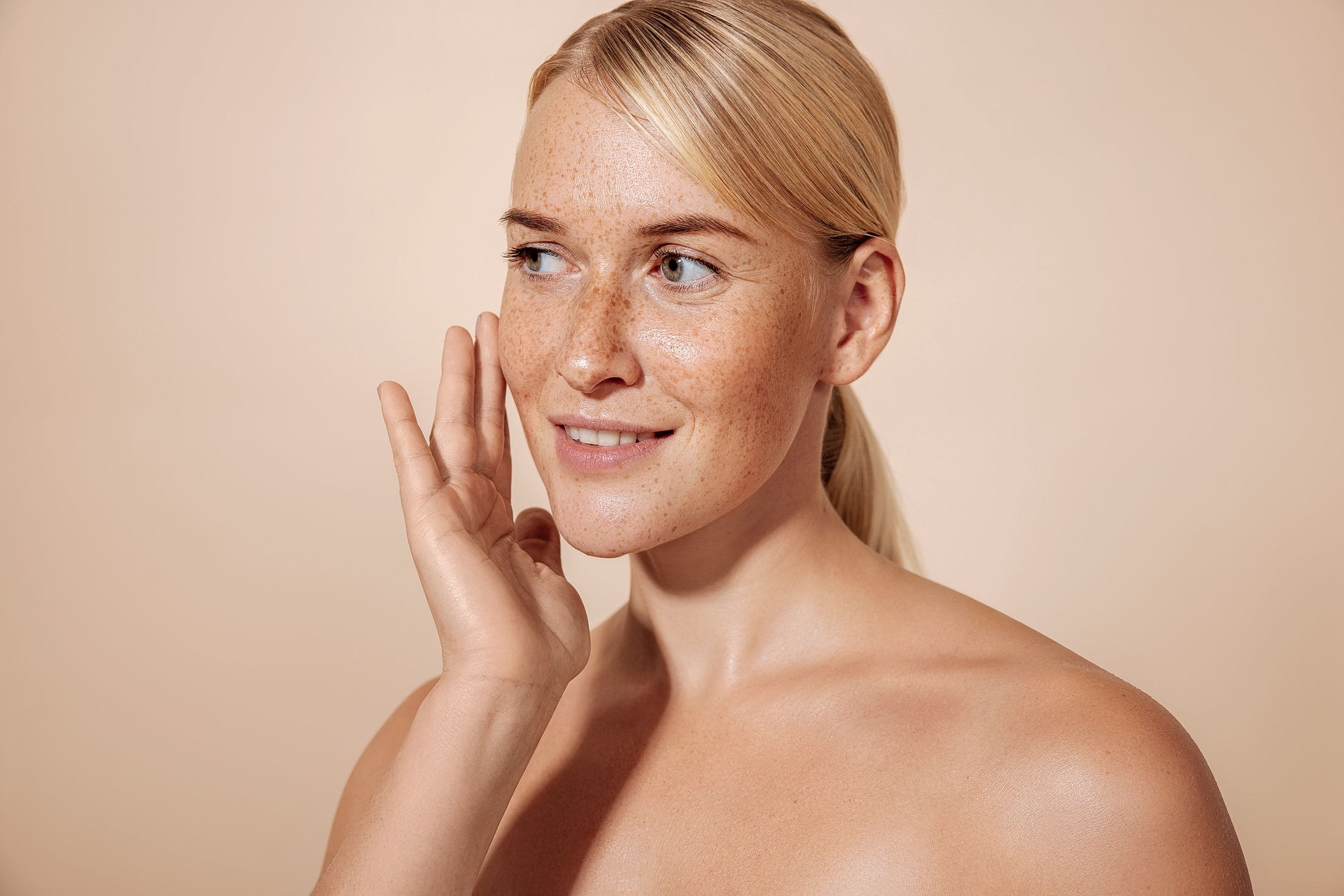Smiling woman touching her face, natural beauty.